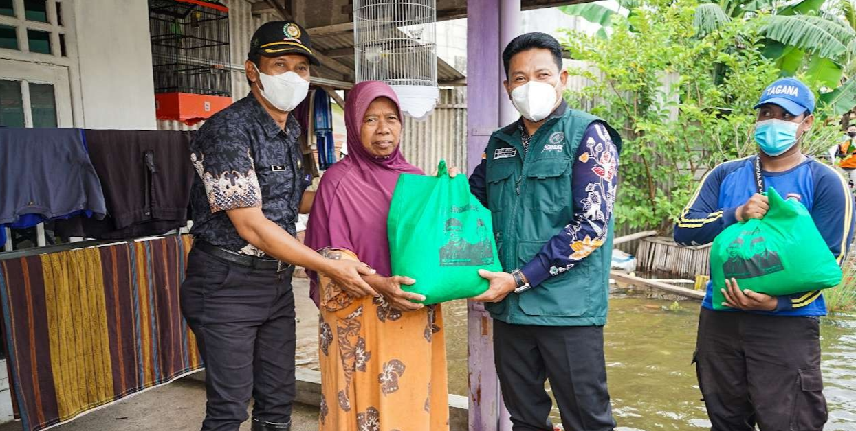 Wabup Subandi (rompi hijau) berikan bansos kepada warga terdampak genangan air. (Foto: Kominfo Sidoarjo)