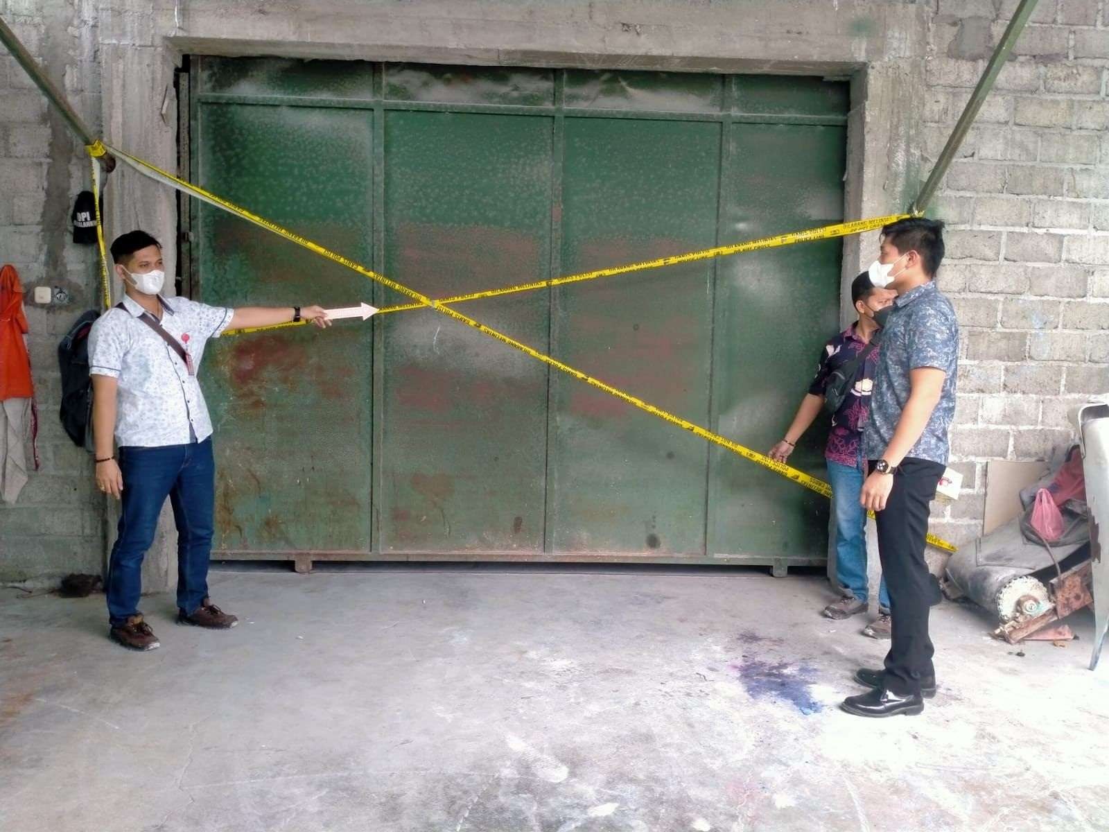 Polisi memasang garis polisi di pintu pabrik pupuk milik tersangka Nurkholis (Foto:Istimewa)