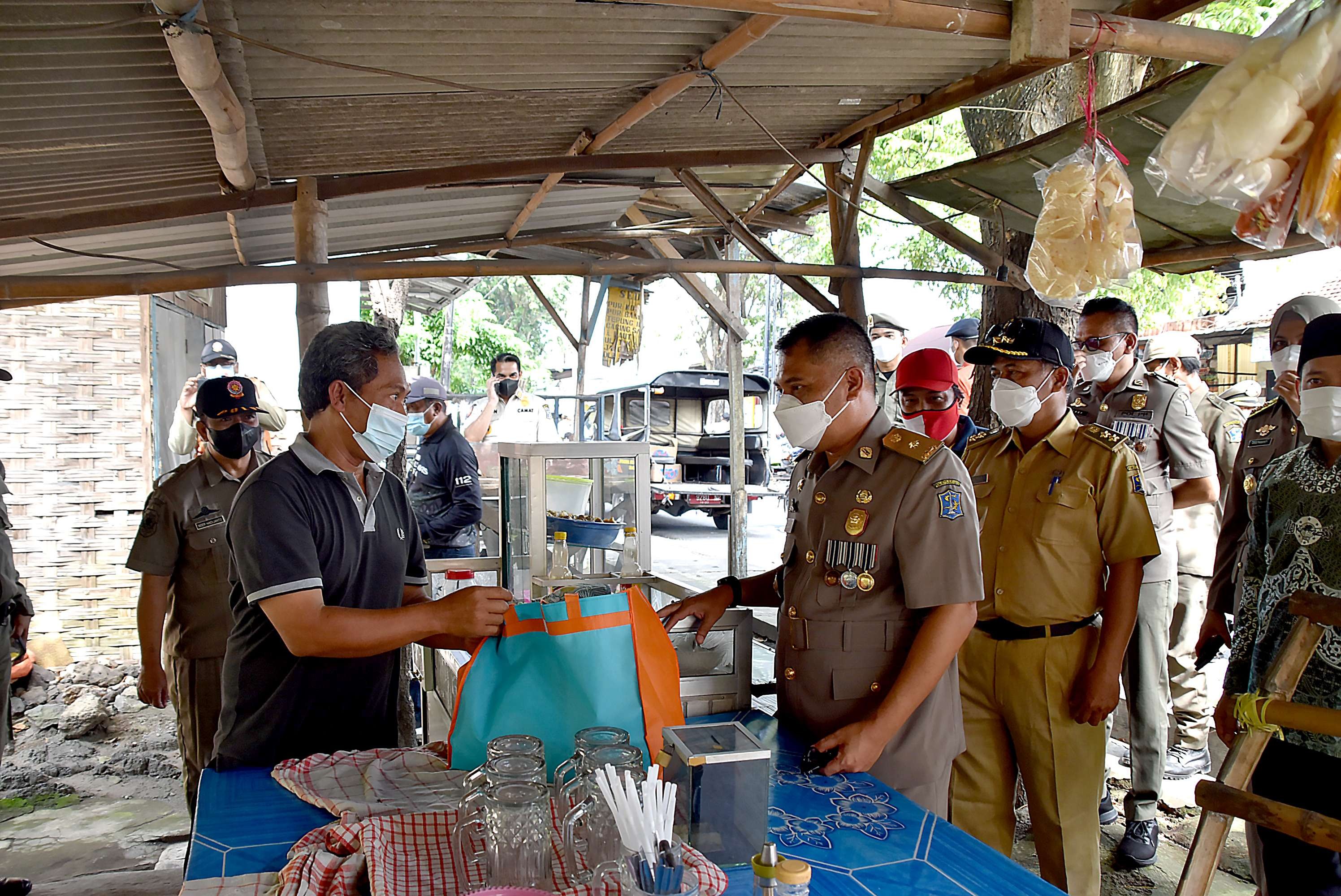 Kasatpol PP Surabaya, Eddy Christijanto saat membagikan langsung minyak goreng dan sembako gratis kepada masyarakat. (Foto: Istimewa)