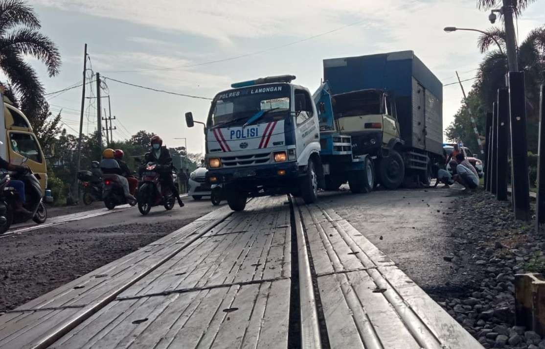 Polisi mengevakuasi truk usai terlibat kecelakaan dengan kereta api di Lamongan. (Foto: Imron Rosidi/Ngopibareng.id)