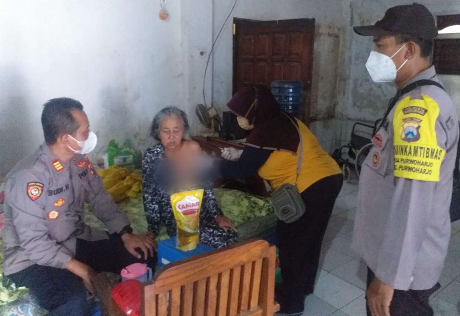 Petugas menyuntikkan vaksin covid-19 pada seorang lansia di Desa Purwoharjo, Banyuwangi, Jawa Timur. Hadiahnya satu liter minyak goreng. (Foto: Istimewa)