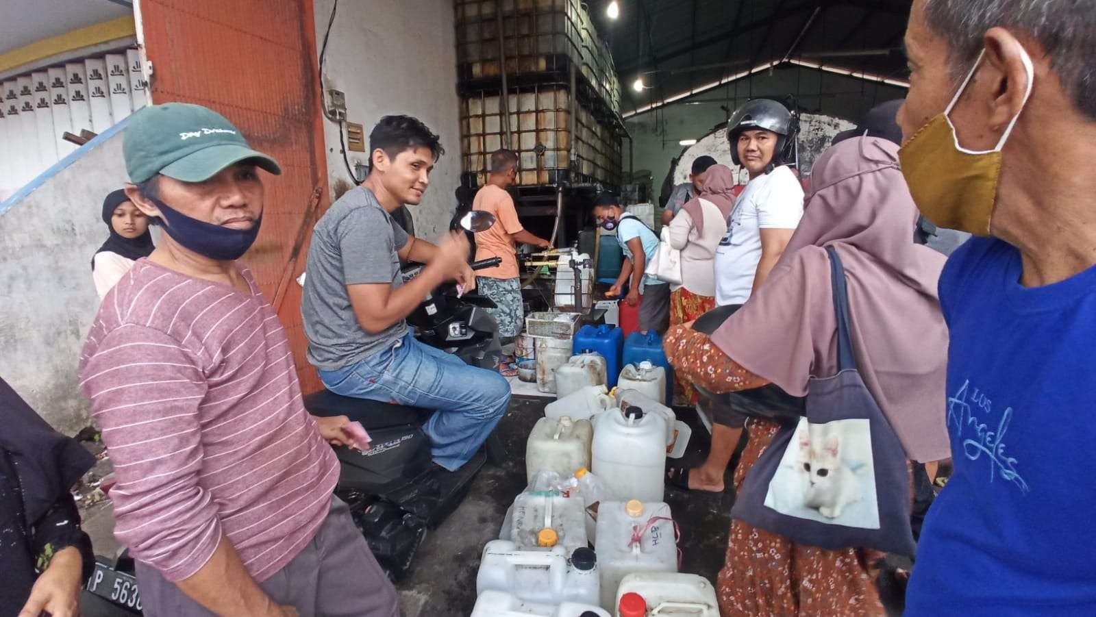 Warga antre untuk membeli minyak goreng curah di sebuah toko di Jalan Jenderal Sudirman Banyuwangi, Jawa Timur. (Foto: Muh Hujaini/Ngopibareng.id)