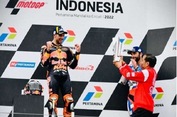 Pebalap tim Red Bull KTM Miguel Oliveira (kiri) tampak berselebrasi sebelum menerima trofi juara MotoGP Grand Prix Indonesia yang disampaikan oleh Presiden Joko Widodo di Sirkuit Pertamina Mandalika, Lombok Tengah, Nusa Tenggara Barat, Minggu 20 Maret 2022. (Foto: Biro Pers Sekretariat Presiden)