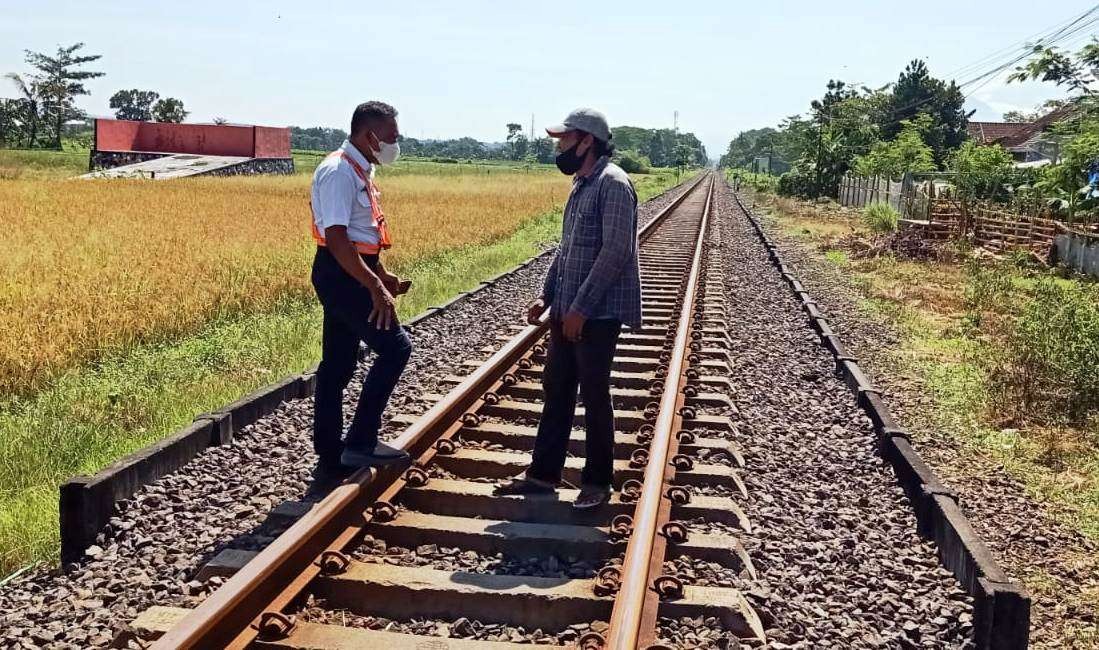 Petugas PT. KAI Daop 9 menegur seorang warga yang berjalan di jalur kereta api. (Foto: Istimewa)