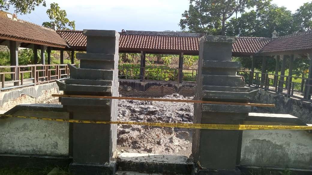 Gapura pintu masuk area petilasan Empu Supo di Desa Dermawuharjo dipasang garis polisi (Khoirul Huda/Ngopibareng.id)
