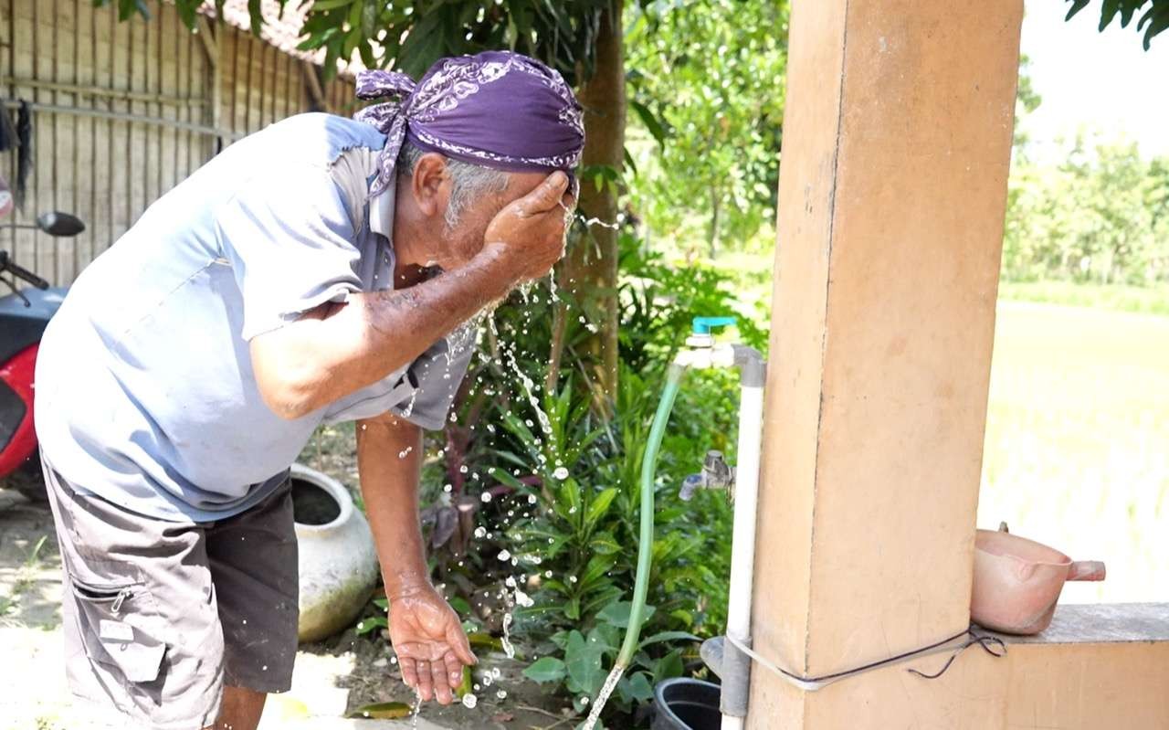Mbah Lasiyo, sesepuh Sedulur Sikep Samin Klopoduwur saat menjajal bantuan air bersih dari Gubernur Jawa Tengah Ganjar Pranowo. (Foto: Istimewa)