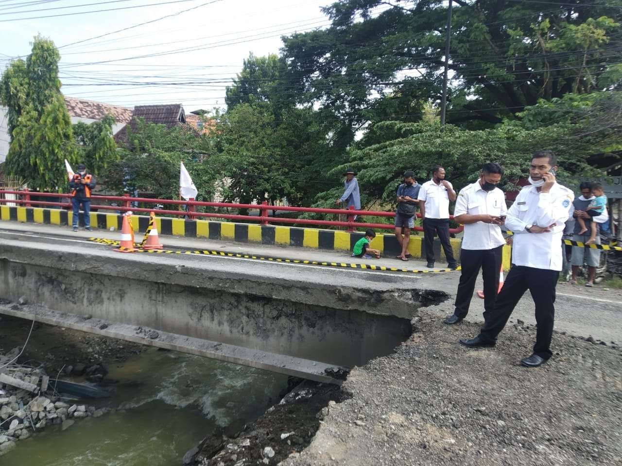 Direktur PDAM Lamongan Ali Makhfudi meninjau lokasi pipa bocor di bawah Jembatan Ngaglik ambrol (Foto : Imron Rosidi/Ngopibareng.id)