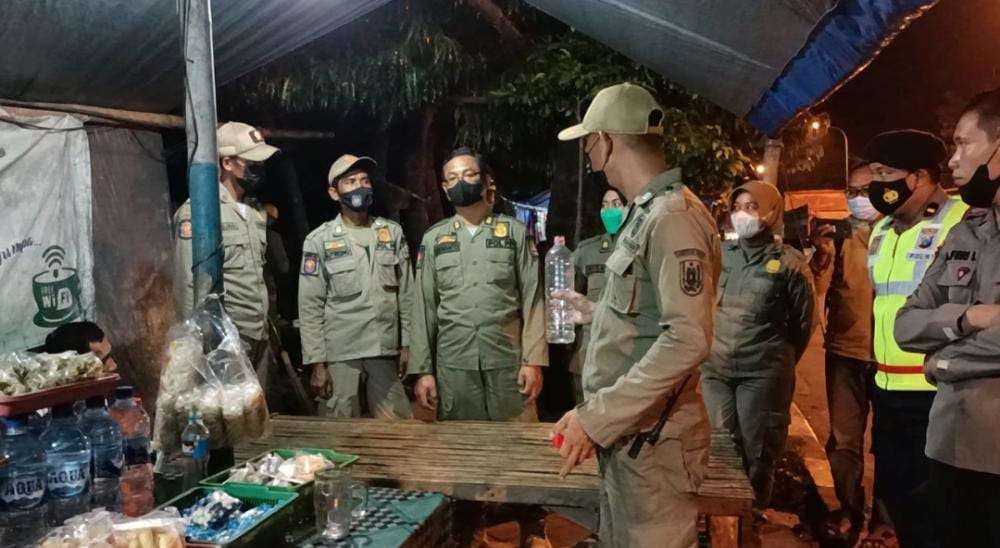 Petugas gabungan ketika mendapati minuman beralkohol di salah satu warung di Tuban, Jawa Timur. (Foto: Khoirul Huda/Ngopibareng.id)