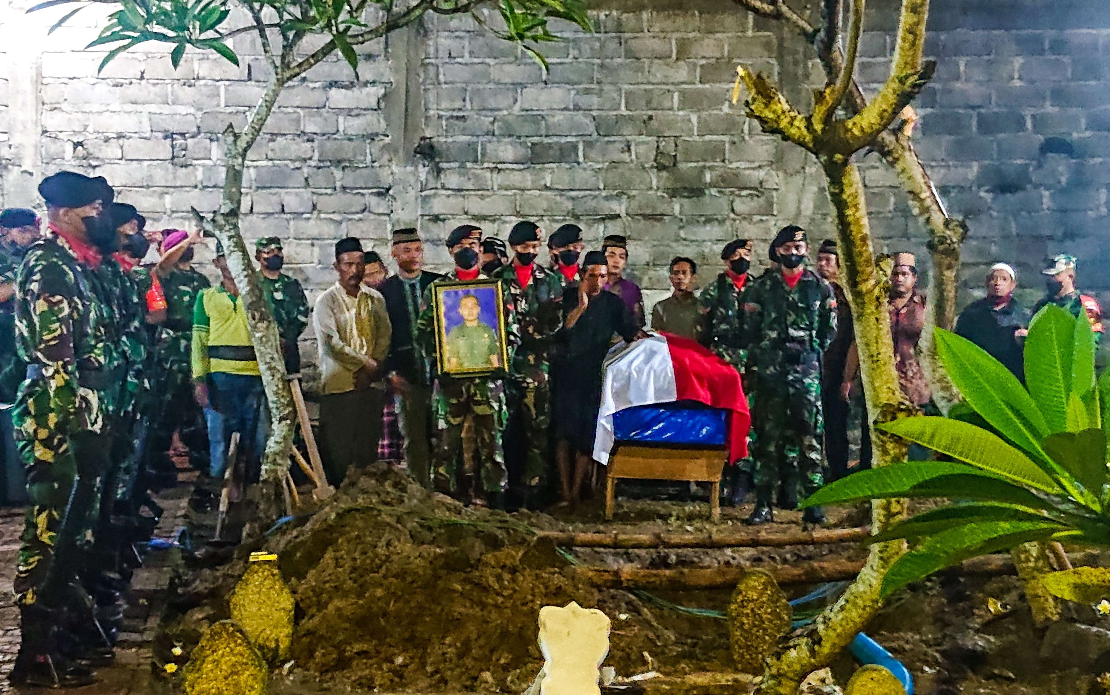Upacara pemakaman Sertu Eka Adriyanto Hasugian  Tempat Pemakaman Umum (TPU) Desa Dungus, Kecamatan Sukodono, Sidoarjo, pada Jumat 1 April 2022, malam. (Foto: Aini Arifin/Ngopibareng.id)