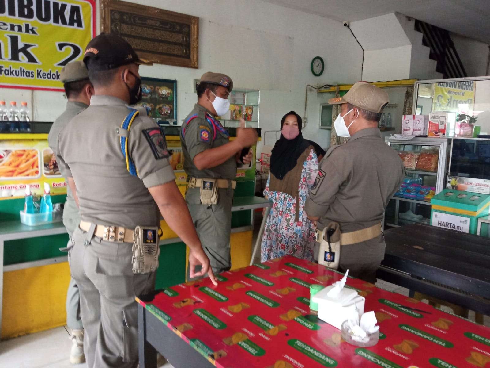 Petugas Satpol PP menyampaikan imbauan kepada pemilik warung makan di kawasan kampus Unej (Foto:Istimewa)