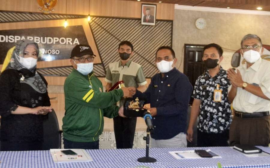 Wakil Ketua Komisi E DPRD Jatim, Artono (jaket hijau) bersalaman dengan Kepala Disparbudpora Bondowoso, Mulyadi. (foto: guido/ngopibareng.id)