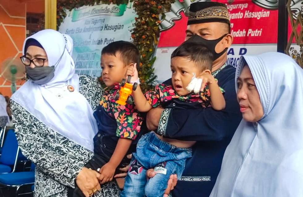 Emi, Ketua IBI pusat (kacamata hitam) menggendong anak Almarhum Sertu Eka (foto:Aini/Ngopibareng.id)