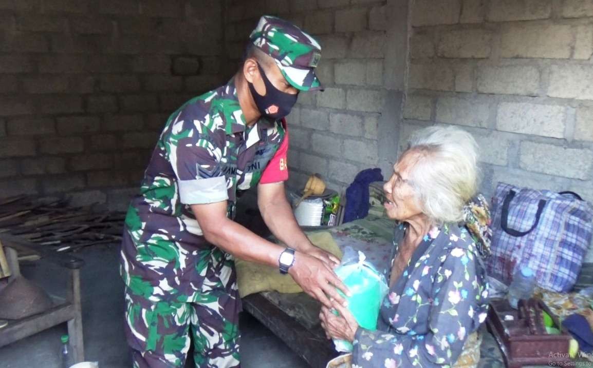 Salah seorang Babinsa mengantarkan rantang berisi makanan kepada seorang lansia (foto: istimewa)