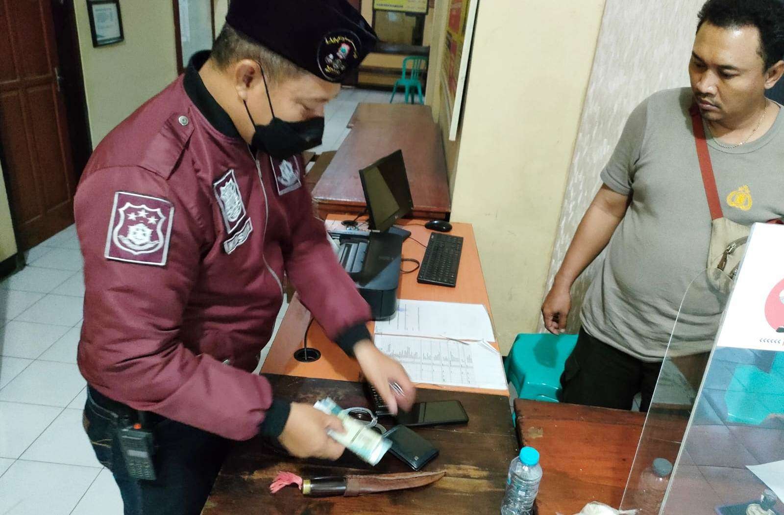 Petugas Polsek Banyuwangi mengamankan pisau dan barang-barang milik pelaku (foto: istimewa)