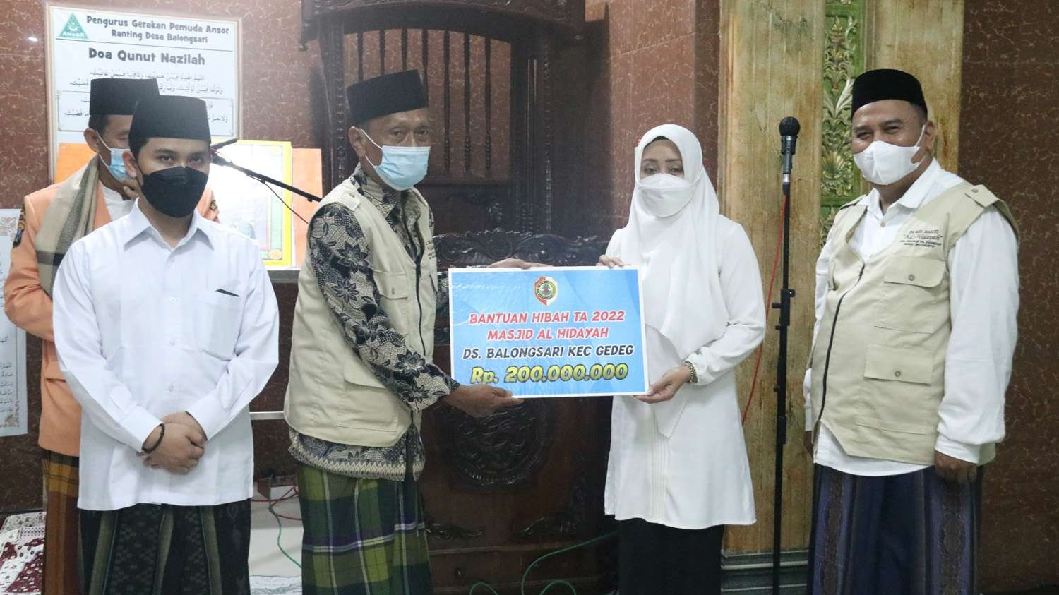 Bupati Mojokerto Ikfina Fahmawati menyerahkan dana hibah kepada takmir Masjid Al Hidayah, Mojokerto, Kamis 14 April 2022. (Foto: Diskominfo Kabupaten Mojokerto)