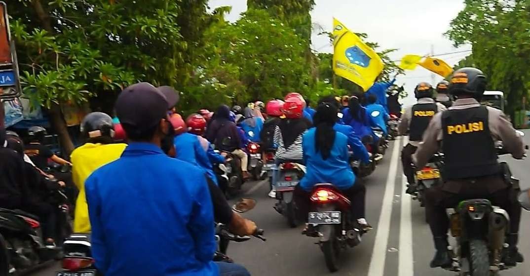 Iring-iringan sepeda motor mahasiswa tergabung dalam PMII Cabang Bojonegoro, aksi demo saat melintas di Jalan Veteran Bojonegoro, Senin 18 April 2022.(Foto: Sujatmiko/Ngopibareng.id)