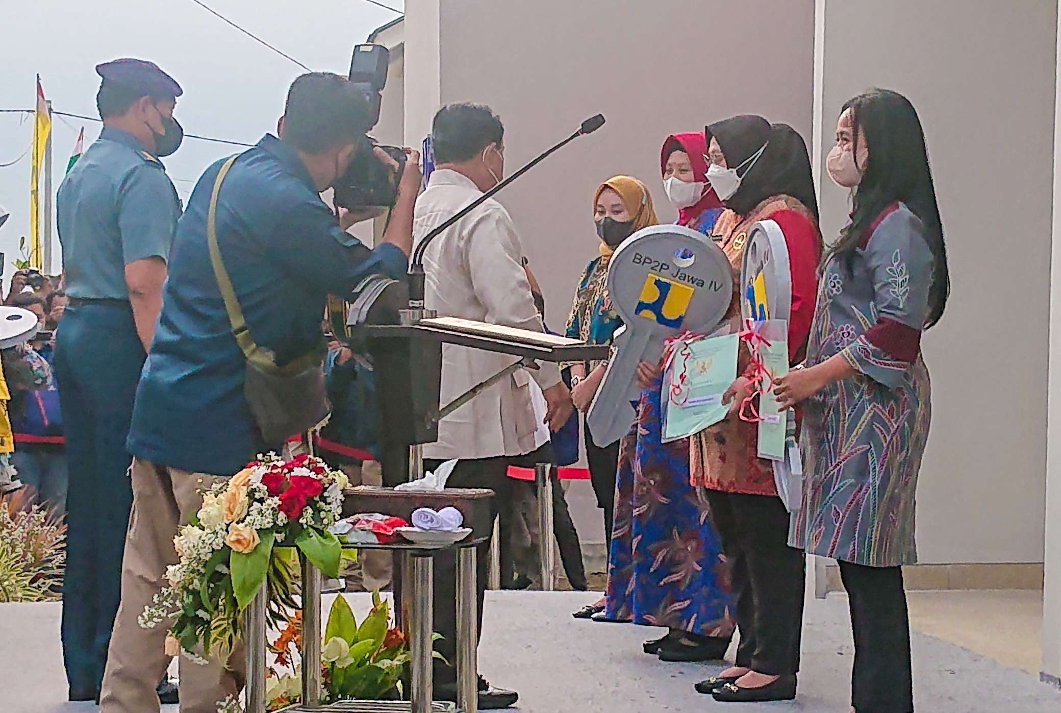Menham Prabowo (baju krem) menyerahkan kunci rumah kepada ahli waris korban KRI Nanggala (foto:Aini/Ngopibareng.id)