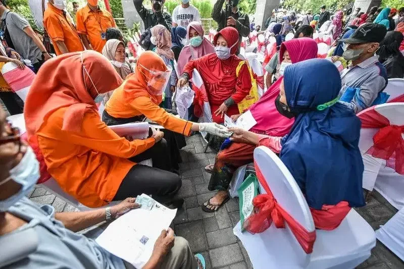 Petugas PT Pos Indonesia menyalurkan BLT minyak goreng kepada warga di Kecamatan Rungkut, Kota Surabaya, Jawa Timur. (Foto: Ant)