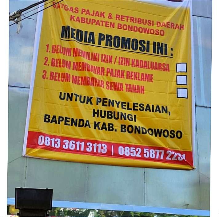 Papan baliho milik Kantor Pos Bondowoso disegel, karena empat tahun belum membayar restribusi Pajak. (Foto: Guido Saphan/Ngopibareng.id)