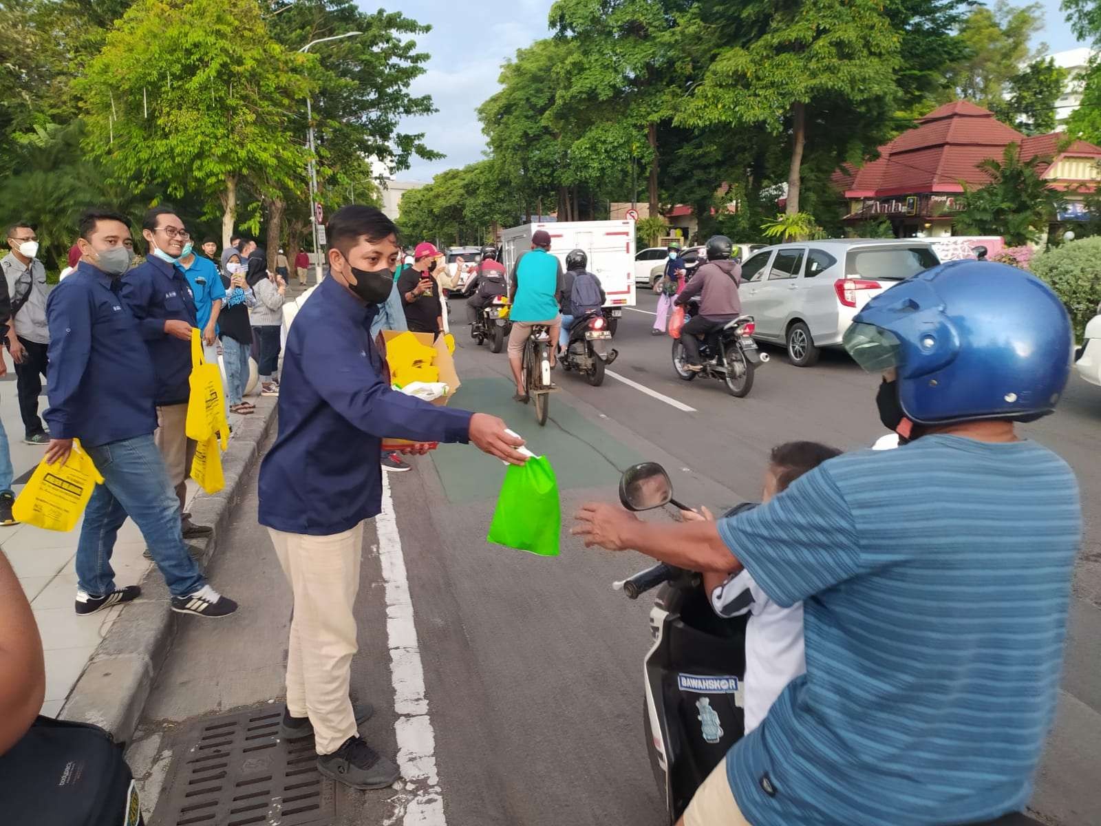 Pembagian takjil menggunakan kantong plastik ramah lingkungan, yang dilakukan Pokja Wartawan Taman Surya Surabaya. (Foto: Istimewa)