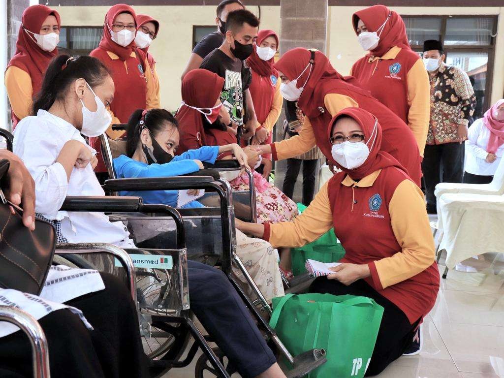 Tim Penggerak PKK Kota Pasuruan membagikan  paket sembako kepada penyandang disabilitas dan anak yatim piatu. (Foto: istimewa)