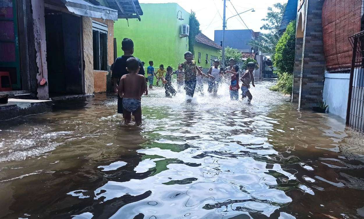 Banjir rob yang terjadi di wilayah Kelurahan Kepatihan justru dimanfaatkan anak-anak untuk bermain. (Foto: Muh Hujaini/Ngopibareng.id)