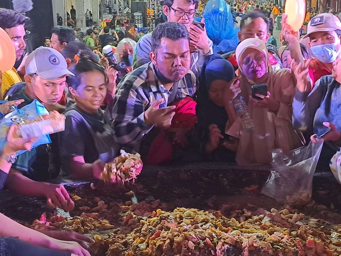 Warga Surabaya berebut rujak uleg di cobek besar Festival Rujak Uleg, Minggu 22 Mei 2022. (Foto: Pita Sari/Ngopibareng.id)
