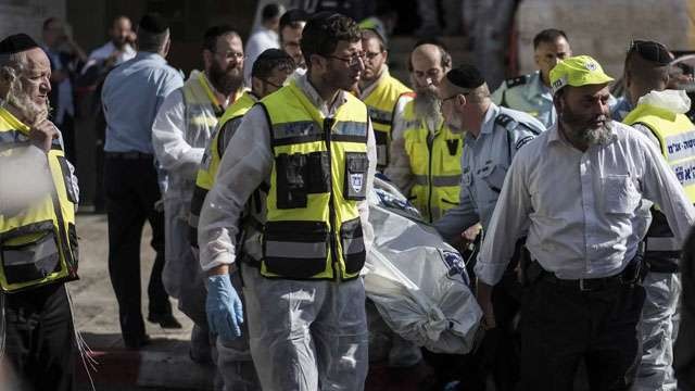 Petugas kesehatan mengevakuasi mayat warga Israel akibat kericuhan yang terjadi di sebuah Sinagog di Yerussalem November tahun 2014. Ilustrasi untuk tulisan; Siklus 80 Tahunan, Israel di Ambang Kebinasaan, Ini Kata Al Quran. (Foto:Time)