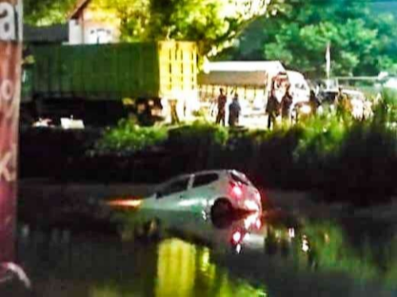 Mobil Daihatsu Ayla terjun ke sungai di Sidoarjo, Jawa Timur setelah diserempet truk yang tidak diketahui nopolnya. (Foto: Istimewa)