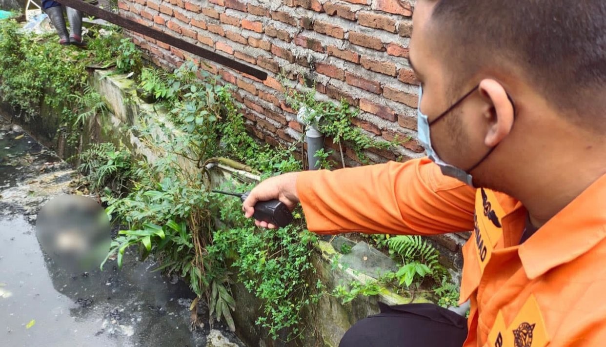 Petugas BPBD Kota Surabaya saat menunjukkan lokasi ditemukannya bayi di sungai kawasan Jemur Ngawinan, Surabaya. (Foto: Istimewa)