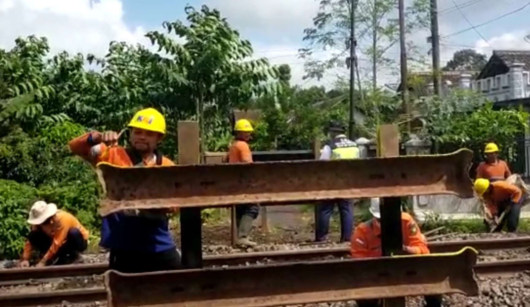 Petugas memasang pagar untuk menutup perlintasan sebidang kereta api. (Foto: Istimewa)