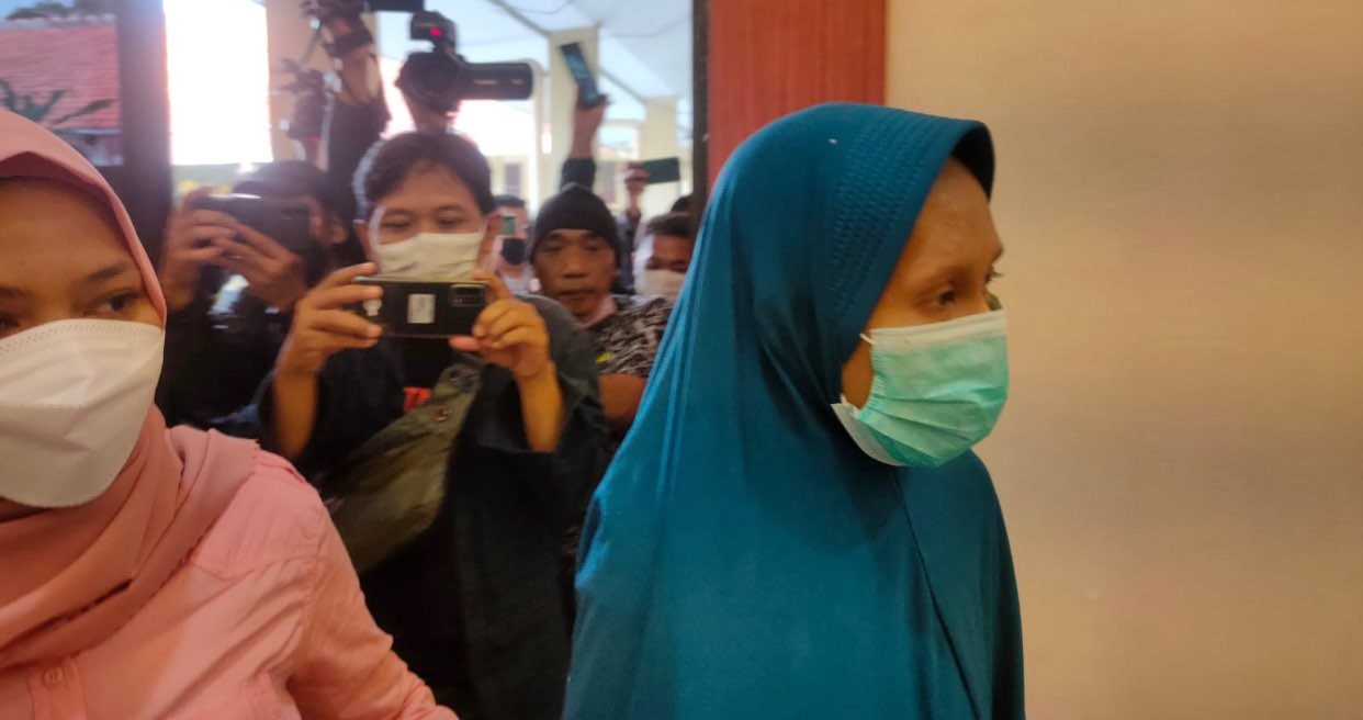 Pelaku pembunuh bayi di Siwalankerto (kerudung biru) saat berada di Mapolsek Wonocolo Surabaya. (Foto: Andhi Dwi/Ngopibareng.id)