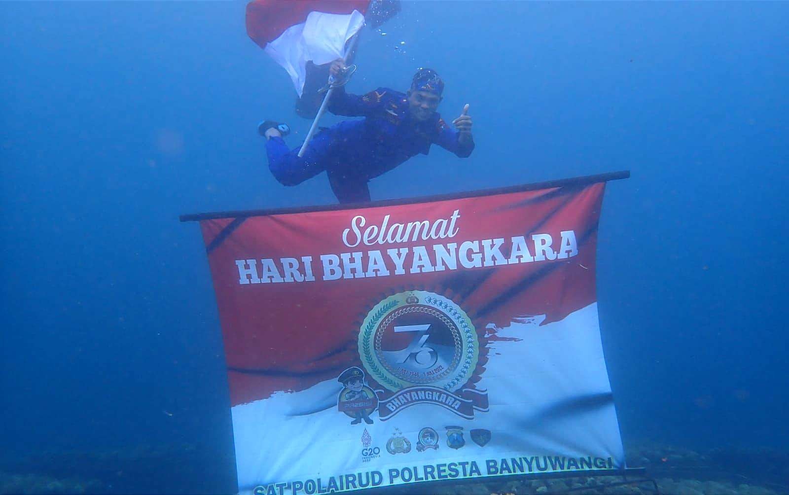 Personil Satpolairud Polresta Banyuwangi mengibarkan bendera merah putih di kedalaman 10 meter perairan selat Bali. (Foto: Istimewa)