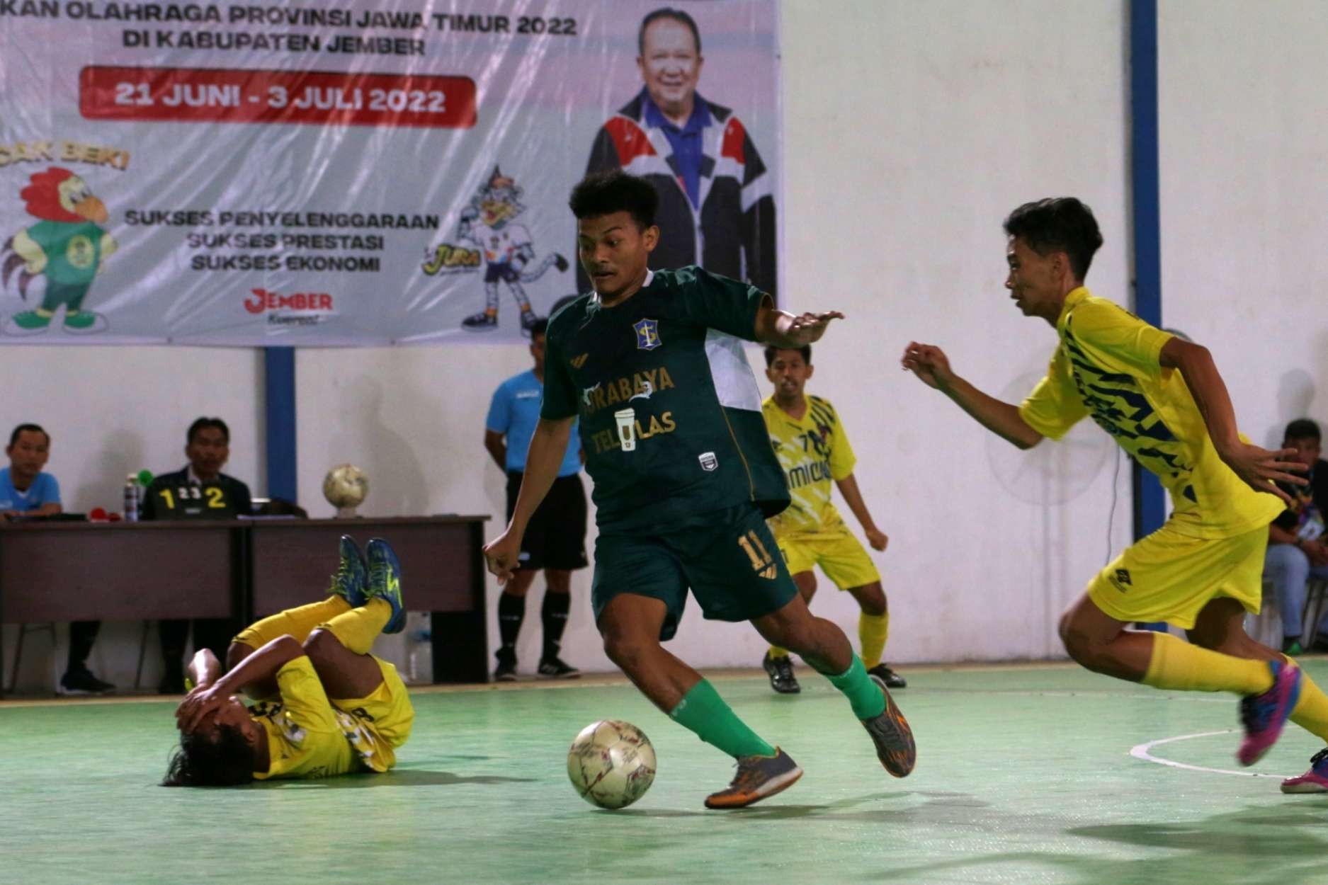 Pemain Surabaya, Rofi'i (hijau) melewati pertahanan Magetan di babak delapan besar Porprov VII Jatim di Gedung Gudang Resi, Jember, Kamis 30 Juni 2022. (Foto: Fariz Yarbo/Ngopibareng.id)