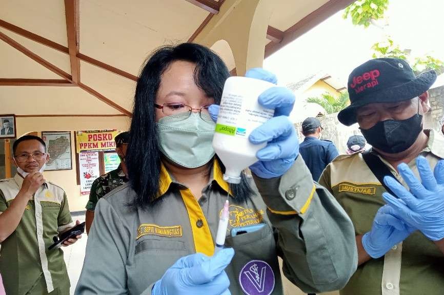 Tim vaksinasi dari DKPPP Kabupaten Tuban sedang mempersiapkan vaksin yang akan disuntikkan ke sapi (Khoirul Huda/Ngopibareng.id)