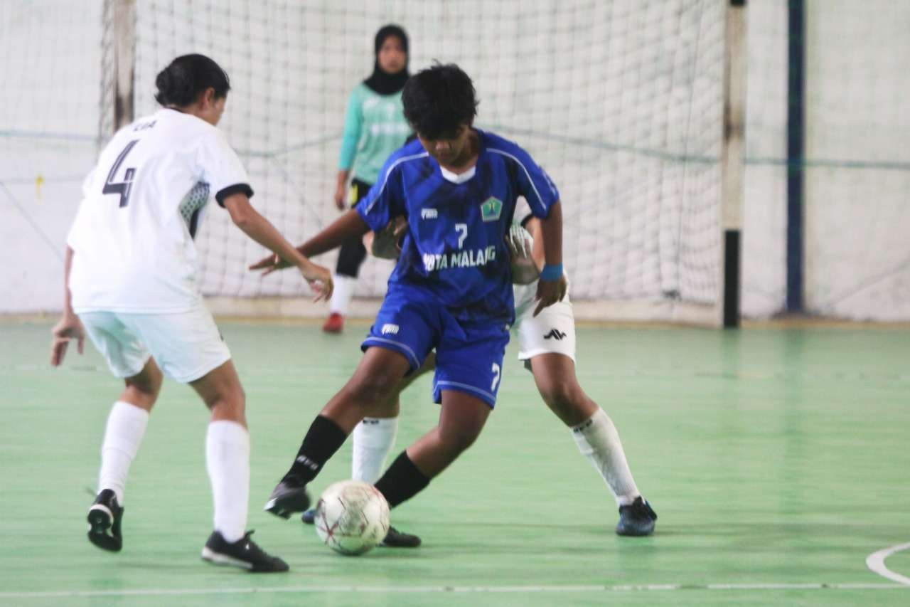 Pemain tim Futsal putri Kota Malang diapit dua pemain Kabupaten Blitar di laga final futsal putri Porprov Jatim VII 2022, Minggu, 3 Juli 2022 di lapangan Gudang Resi, Jember. (Foto: Istimewa)