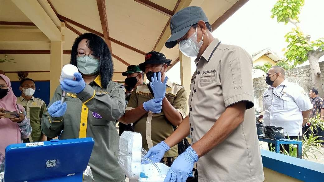 Petugas vaksinator sedang menyiapkan suntikan vaksin tahap pertama untuk hewan ternak di Desa Kembangbilo, Tuban (Khoirul Huda/Ngopibareng.id)