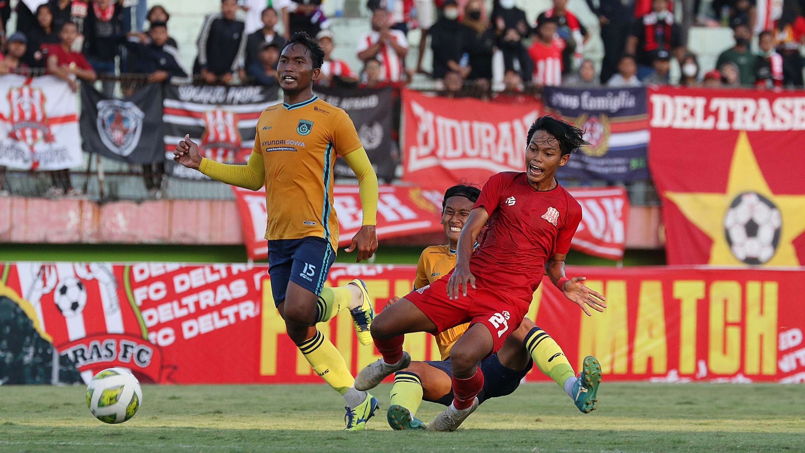Pemain Deltras FC, Risal Amin (merah), mendapat hadangan dari pemain Gresik United dalam laga uji coba di Stadion Gelora Delta, Sidoarjo, Sabtu 30 Juli 2022. (Foto: Fariz Yarbo/Ngopibareng.id)