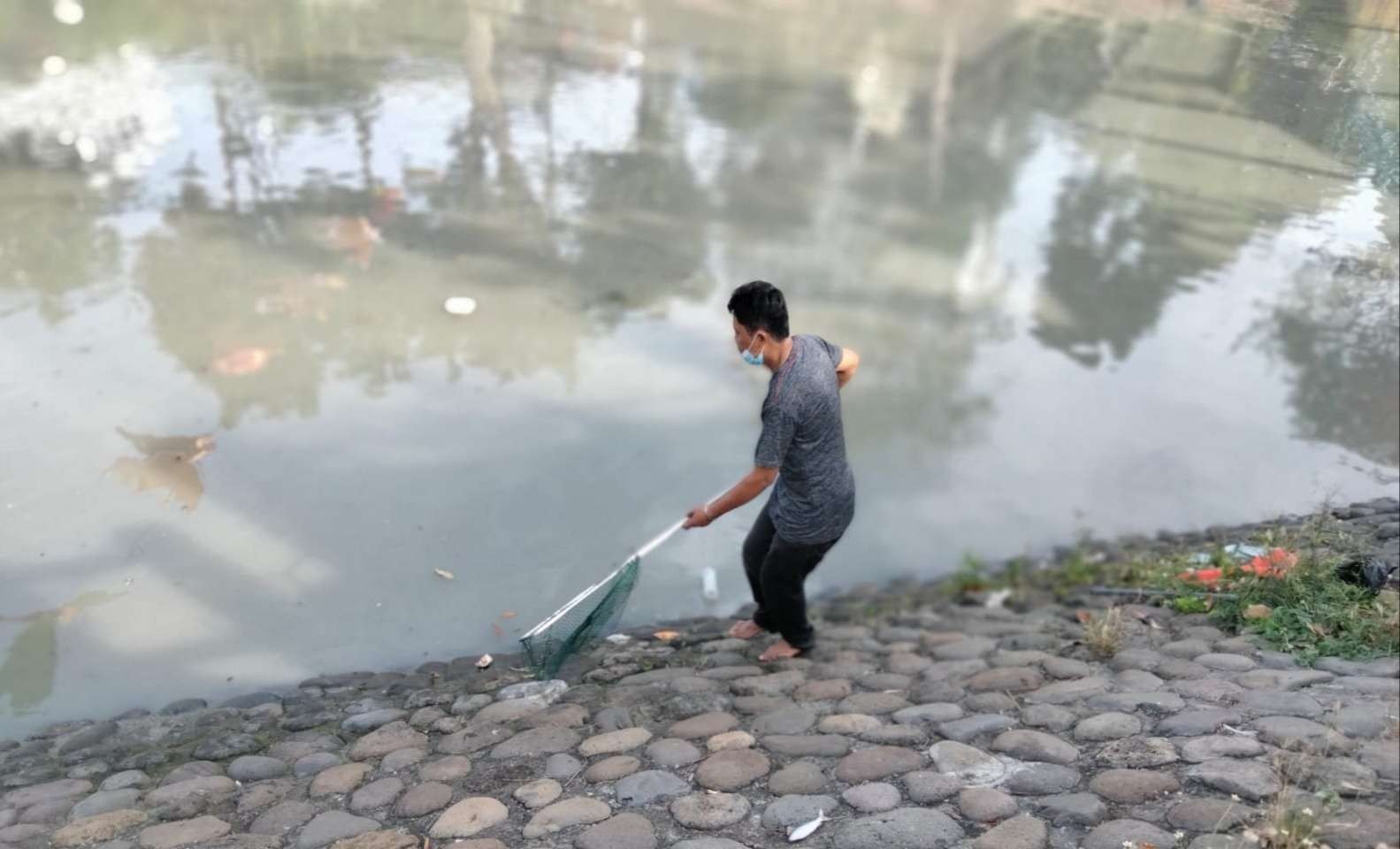 Warga mengambil ikan mabuk di sungai dekat Taman Prestasi Surabaya, Selasa 2 Agustus 2022. (Foto: Istimewa)