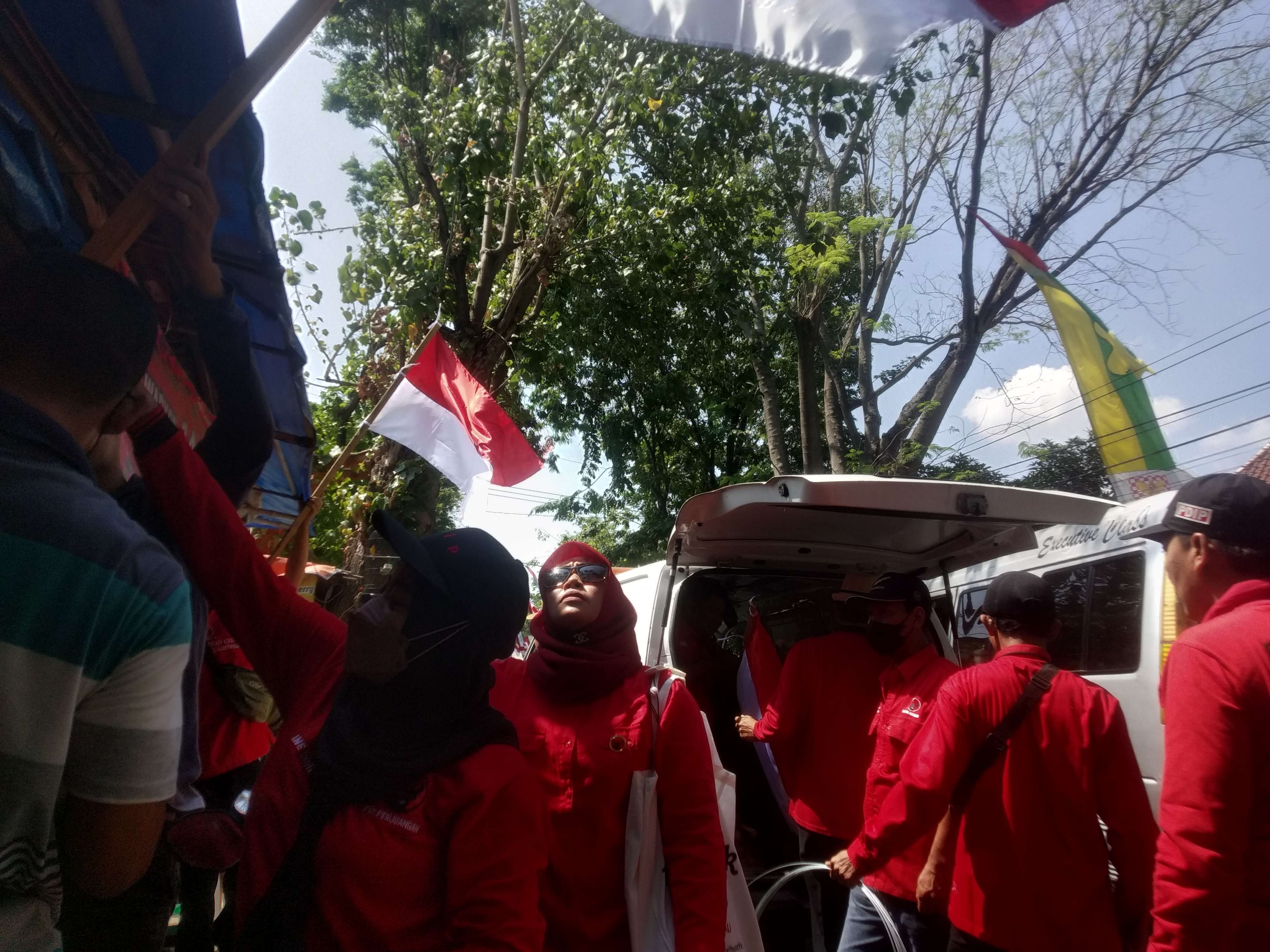 DPC PDI P Lamongan membagikan bendera merah putih kepada PKL. (Foto: Imron Rosidi/Ngopibarengi.id)