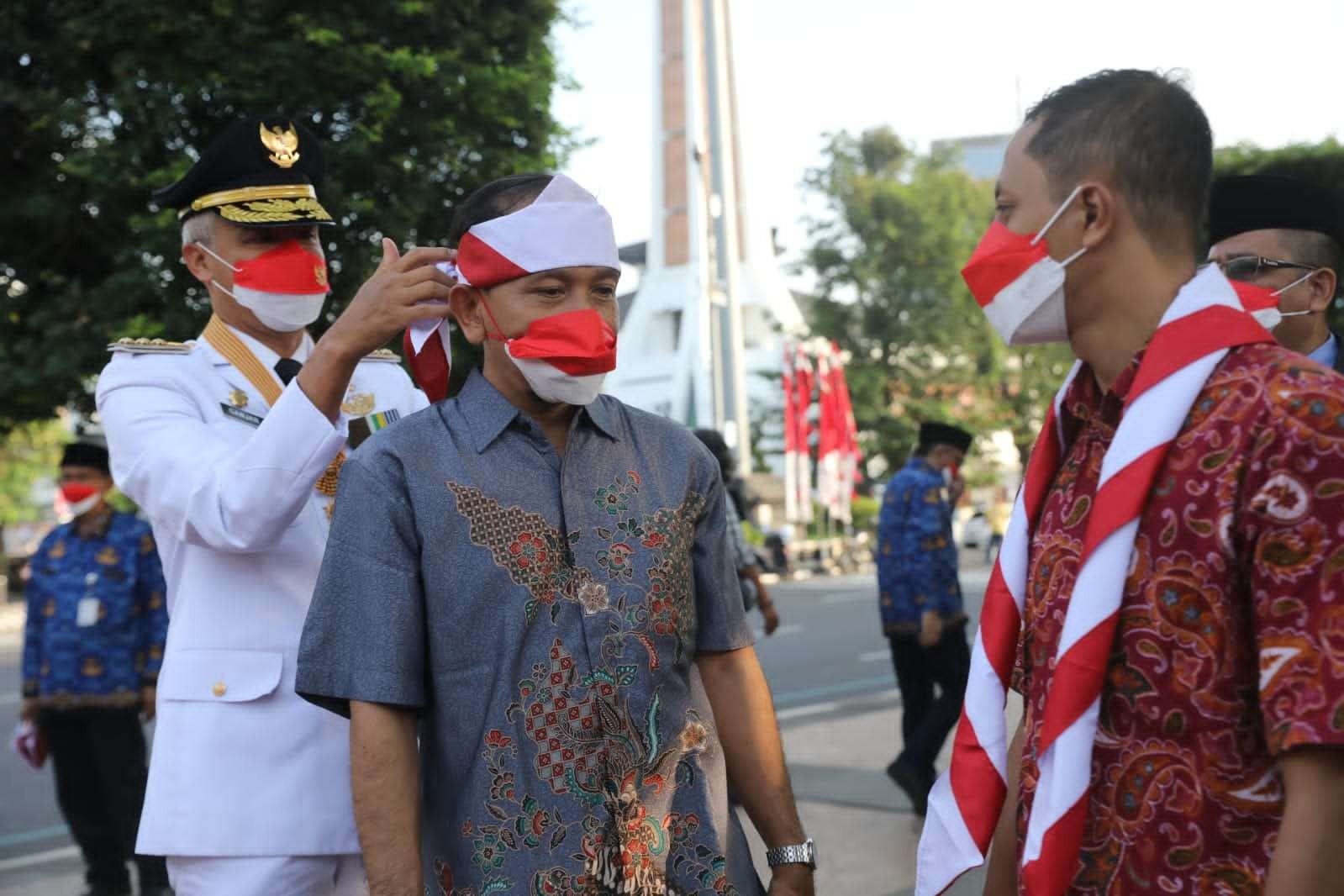 Gubernur Jawa Tengah Ganjar Pranowo yang  bertindak sebagai inspektur upacara secara khusus menyematkan hasduk merah putih di kepala Joko Priyono, salah seorang eks napiter. (Foto: Dokumentasi Pemprov Jateng)