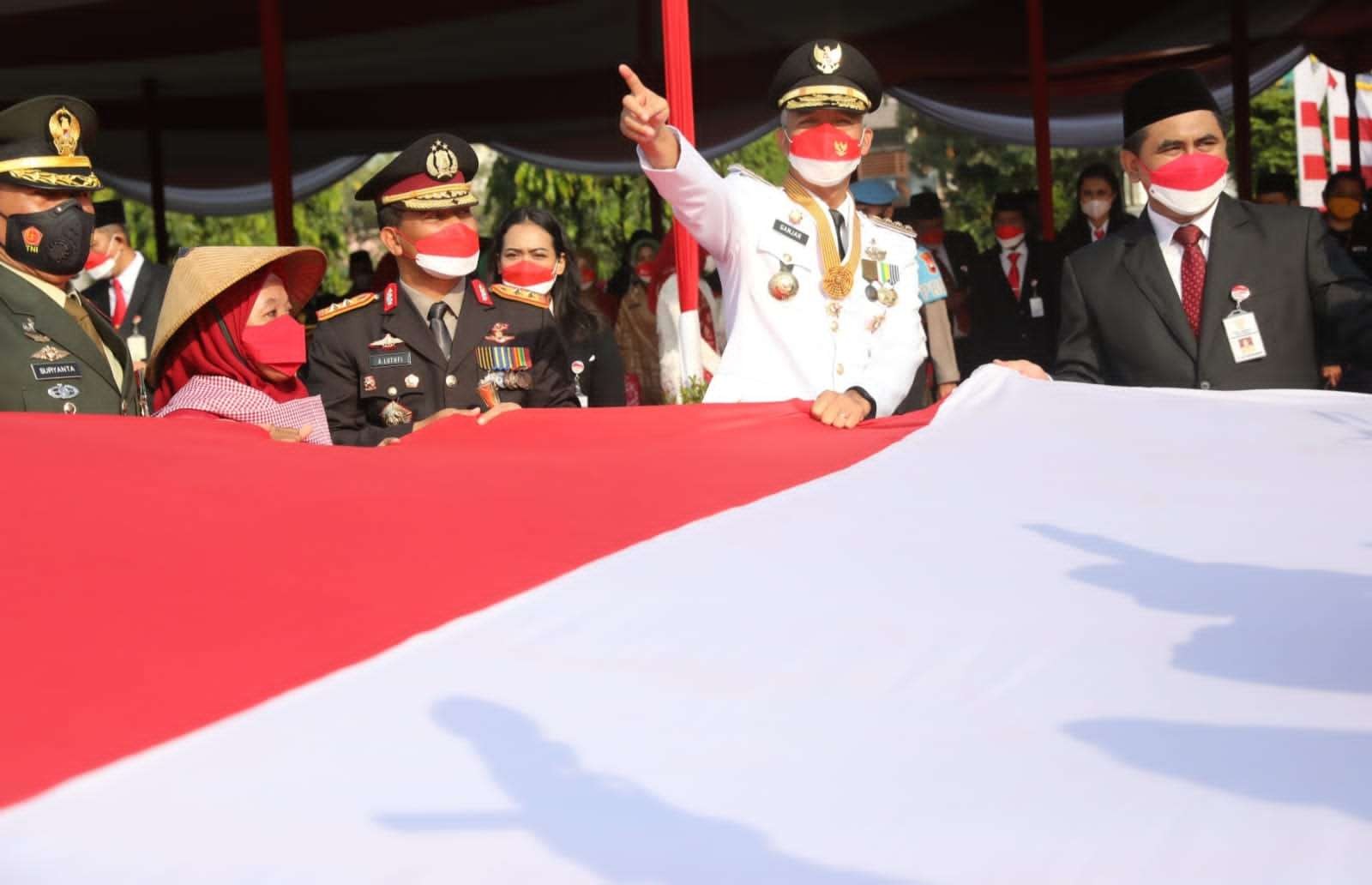 Buruh migran memberikan bendera merah putih ukuran besar kepada Gubernur Jateng Ganjar Pranowo di Lapangan Pancasila Semarang, Rabu 17 Agustus 2022. (Foto: Dokumentasi Pemprov Jateng)