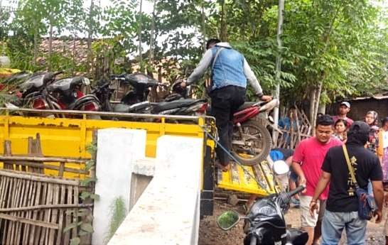 Anggota Polsek Banyuglugur Polres Situbondo mengamankan sepeda motor dari lokasi judi sabung ayam.(Foto: Humas Polres Situbondo)