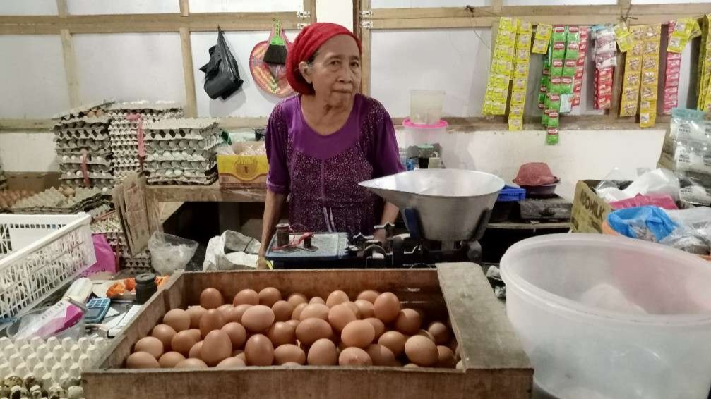 Penjual telur dan bahan pokok di Pasar Baru Tuban sedang melayani pembeli (Foto: Khoirul Huda/Ngopibareng.id)