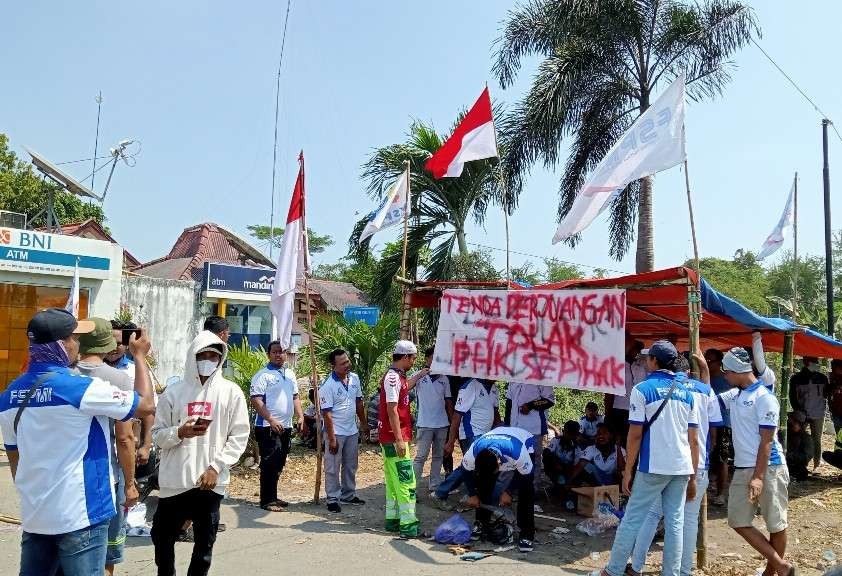 Massa buruh dari FSPMI Tuban mendirikan tenda perjuangan di depan pabrik PT. IKSG Tuban (Foto: Khoirul Huda/Ngopibareng.id)