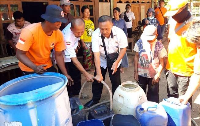 Petugas BPBD Situbondo mendistribusikan bantuan air bersih kepada warga Desa Jatisari, Kecamatan Arjasa. (Foto: BPBD Situbondo)