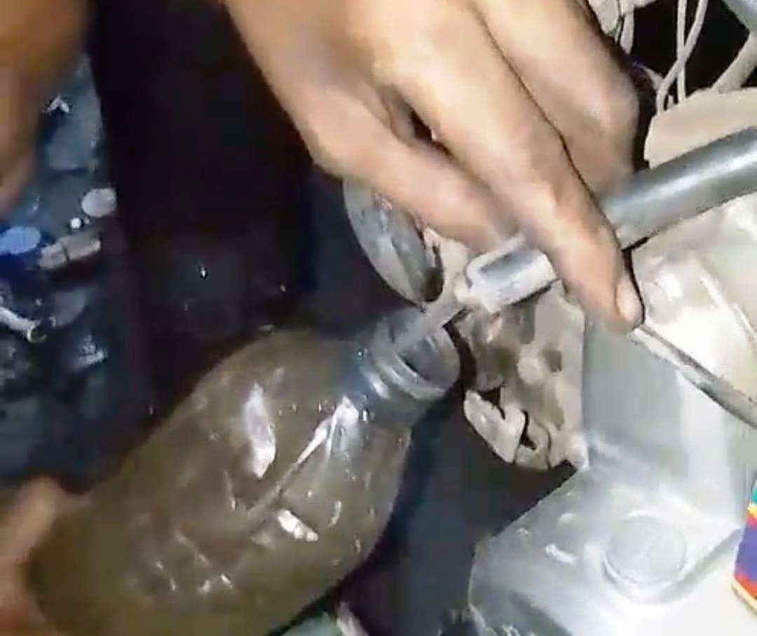 Tangkapan layar video yang menggambarakan warga sedang menguras isi tangki BBM motor karena diduga BBM yang di isi dari SPBU bercampur air (istimewa)
