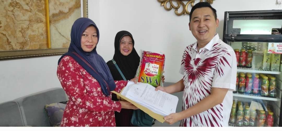 Roni Siswanto, Ketua DPD Partai Solidaritas Indonesia (PSI) Kota Kediri, mendekatkan diri kepada warga dengan menjual sembako dengan harga terjangkau.  (Fendy Plesmana/Ngopibareng.id)