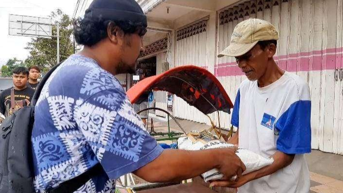 Anggota Resmob Satreskrim Polresta Banyuwangi menyerahkan sembako kepada seorang tukang becak (Foto: Muh Hujaini/Ngopibareng.id)