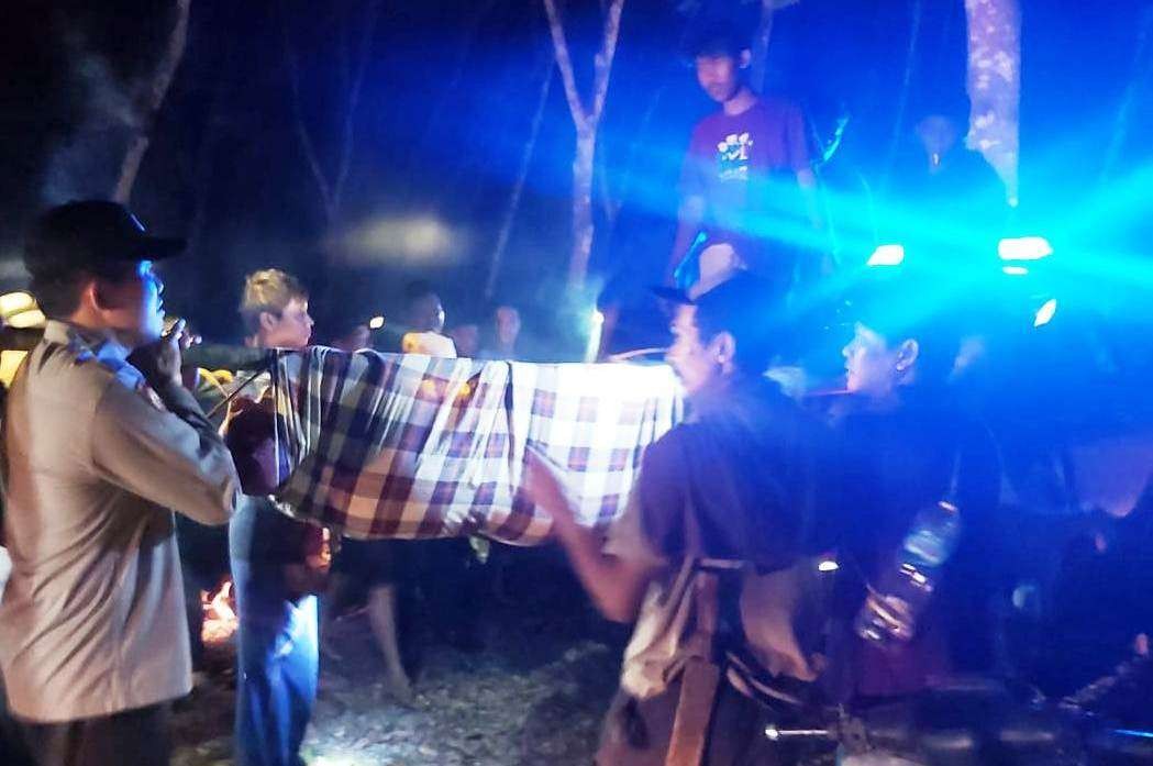 Petugas Polsek Pesanggaran bersama warga mengevakuasi kenazah pemburu madu yang meninggal dunia (foto:istimewa)